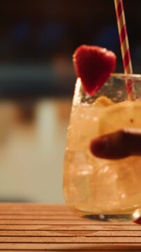 Fruit cocktail in hotel bar, Two cocktail glasses cheers in the hands on sea background. Bartenter making drink in bar, Summer vacation concept, A beautiful couple enjoy the vacation at the beach.