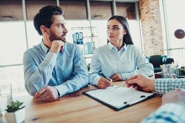 Professional colleagues collaborating in an office, preparing documents during a formal meeting to...