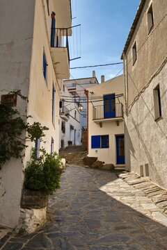 Empty narrow streets of Cadaqu&eacute;s, Spain, with white houses and clear blue sky. The peaceful historic town center is beautifully captured without any people, highlighting its charm and tranquility.