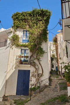 Empty narrow streets of Cadaqu&eacute;s, Spain, with white houses and clear blue sky. The peaceful historic town center is beautifully captured without any people, highlighting its charm and tranquility.