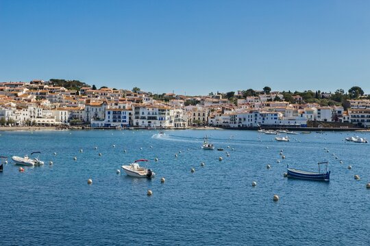 Charming Cadaqu&eacute;s, with small boats, white houses and vibrant blue sky, showcasing the historic Mediterranean coastal town&rsquo;s beauty and traditional architecture