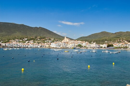Charming Cadaqu&eacute;s, with small boats, white houses and vibrant blue sky, showcasing the historic Mediterranean coastal town&rsquo;s beauty and traditional architecture