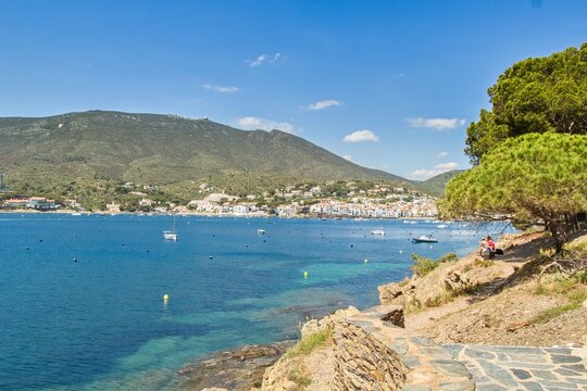 Charming Cadaqu&eacute;s, with small boats, white houses and vibrant blue sky, showcasing the historic Mediterranean coastal town&rsquo;s beauty and traditional architecture