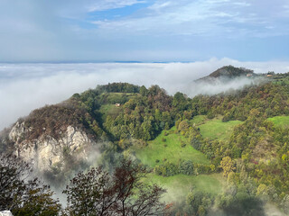 Misty mountains and lush valleys above cloud layer