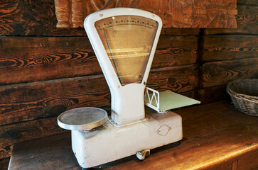 An old scale sits on a wooden table