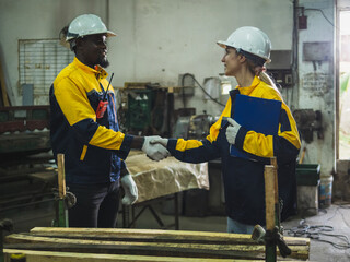 Industrial engineer technician worker man woman with helmet  uniform safety vest look shake hands...