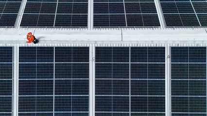 Solar power technician inspecting rooftop solar panels, performing maintenance and installation of...