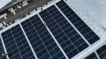 Solar power technician inspecting rooftop solar panels, performing maintenance and installation of...