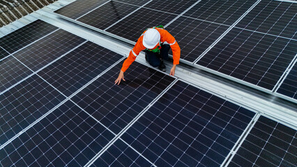 Solar power technician inspecting rooftop solar panels, performing maintenance and installation of...
