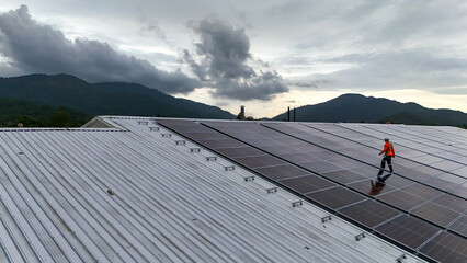 technician installs a large photovoltaic system on an industrial rooftop. ESG investment, and the...