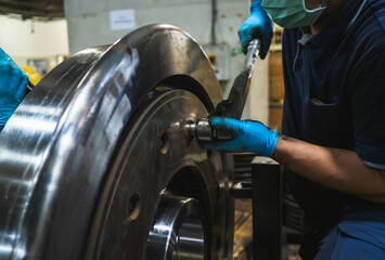 Close-up engineer technician craftsman one person hand wear glove safety protective holding wrench tool tighten torque nut standard value for job repair product in machine workshop industrial factory