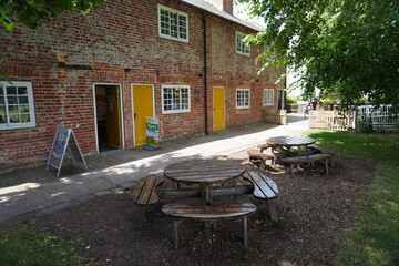 Beeston, Nottinghamshire, England - June 20 2025: Charming brick building with bright yellow doors,...
