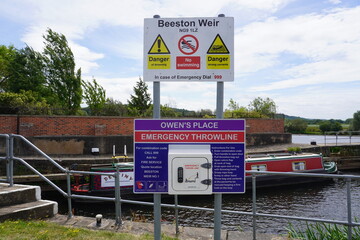 Nottingham, England - June 20 2025: Safety signage and throwline station with narrowboat on River...