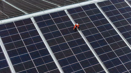technician installs a large photovoltaic system on an industrial rooftop. ESG investment, and the...