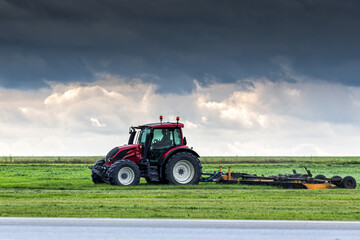 Wheel tractor with lawn mower by the road