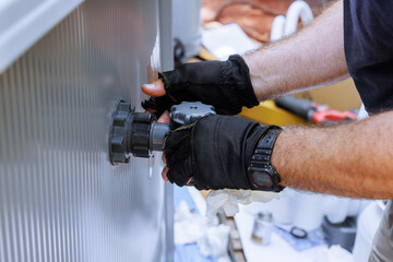 Skilled technician is adjusting mechanical valve filter system to swimming pool