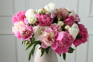 Bouquet of beautiful peonies in vase indoors, closeup
