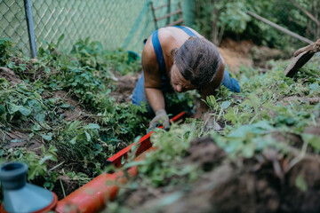 male plumber lays sewer pipe into the ground