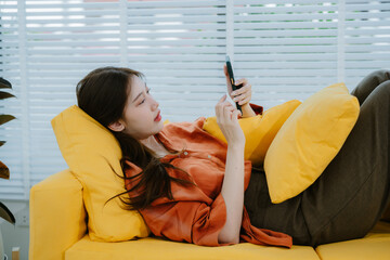 Young attractive beautiful casual asia female lady or student look at cellphone play social media...