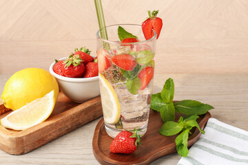 Tasty refreshing drink with strawberries, lemon and mint on wooden table, closeup