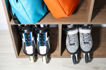 Pairs of roller skates and backpacks in shelving unit