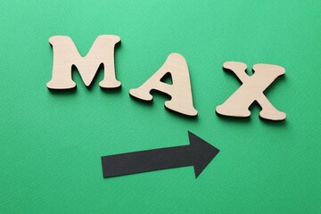 Word Max and arrow on green background, top view