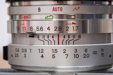 Exploring the intricate details of a vintage camera lens, highlighting its aperture, shutter speed, and various control settings