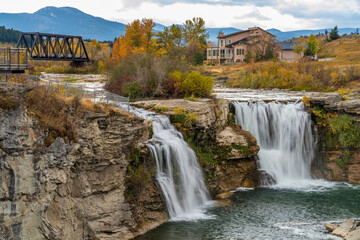 Lundbreck Falls on the Crowsnest River in autumn, with a railway bridge in the background. Alberta,...