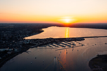 Top down view of a boat returning to dock at Malahide Marina surrounded by other moored sailboats