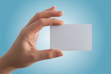 Obraz premium Close up of a woman s hand holding a blank white credit card or business card against a soft blue gradient background