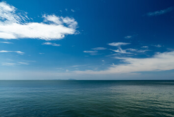 Obraz premium Serene tropical beach with crystal clear turquoise water, gentle waves, and a bright blue sky with fluffy white clouds. peaceful and relaxing summer scene perfect for panorama and travel concepts.