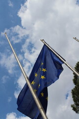 European union flag in the wind on a blue cloudy sky background 