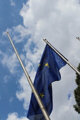 European union flag in the wind on a blue cloudy sky background 
