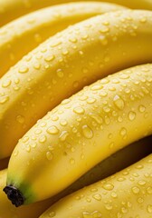 Close-up captures a cluster of ripe bananas, glistening with fresh water droplets.