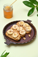 delicious toasts with peanut butter and banana on a plate