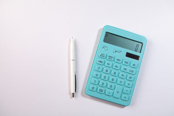 calculator and pen on white background.