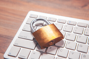 padlock with a laptop on a wooden background.
