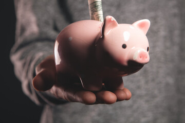 man with piggy bank on a black background