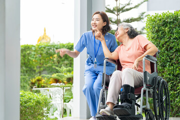 A senior woman with a leg injury laughs with her caregiver during a rehabilitation session. A...
