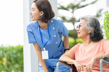 An empathetic caregiver crouches to listen to a senior woman in a wheelchair, demonstrating respect...