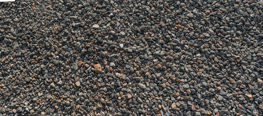 Texture of volcanic gravel ground with black stones and rough surface