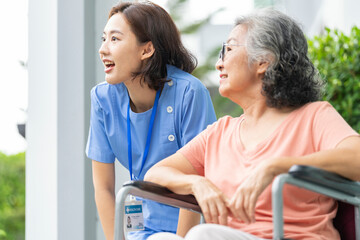 An empathetic caregiver crouches to listen to a senior woman in a wheelchair, demonstrating respect...