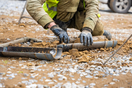 Man cutting and cleaning soil sample for laboratory analysis. Preparation of core material for geotechnical testing and scientific evaluatio