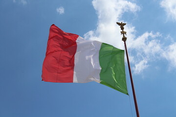 Italian flag in cloudy sky. waving in the sky. Italian flag in a wind on a cloudy blue sky background in Rome