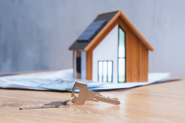 Miniature home with solar panels, keys and deeded dollars. Real estate deal concept, eco-friendly...