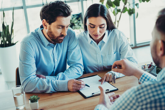 Professional business partners collaborating during a discussion in a modern office setting with stylish formal attire