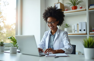 African american woman doctor studies. She researches medical information, prescriptions using laptop. Smiling physician in glasses in modern clinic room, wearing medical uniform, health care.