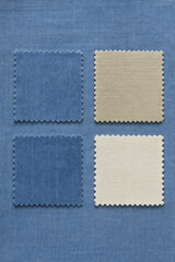 Assortment of blue and beige fabric swatches with zig-zag edges, arranged on a coordinating blue textile background