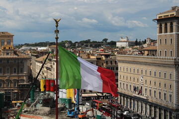 Italian flag waving in wind with Rome in Background 