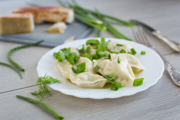 Appetizing dumplings with potatoes and onions on a rustic table